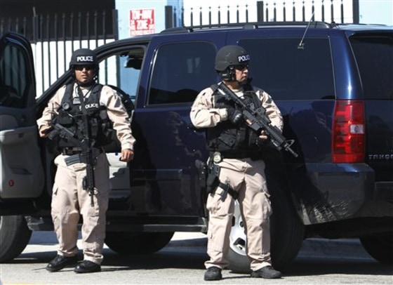 Miami-Dade police officers patrol Thursday near the location of a shootout that killed two Miami-Dade police officers and a murder suspect, authorities said.